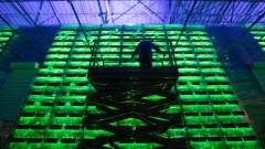A technician on a cherry picker inspects racks of illuminated mining rigs at the Minto cryptocurrency mining center in Nadvoitsy, Russia, on Friday, Dec. 17, 2021. Bitcoin extended its five-week slide from an all-time high with risk sentiment across global financial markets dwindling.