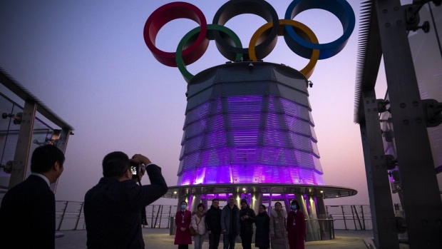 Visitors pose for photographs with the Olympic rings at the observation deck at the Olympic Tower in Beijing, China, on Friday, Jan. 7, 2022. Beijing said it will conduct the winter games in a so-called “closed loop”, with participants only allowed to move between Olympic venues and other related facilities, and to use designated transport services.