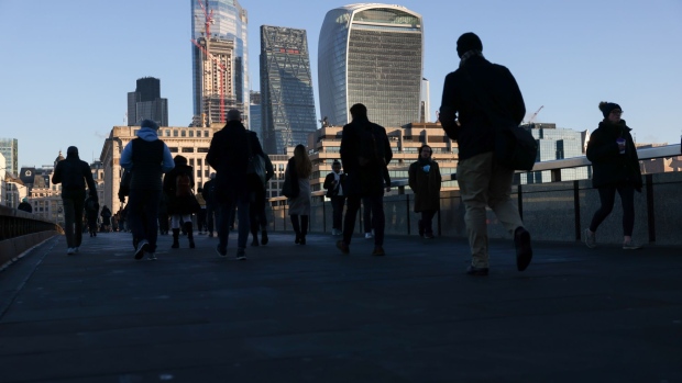 Morning commuters on London Bridge head towards the City of London, U.K., on Tuesday, Jan. 18, 2022. Britain's labor market grew strongly despite a surge in coronavirus infections late last year, with vacancies hitting a record 1.25 million in the fourth quarter and unemployment falling unexpectedly. Photographer: Hollie Adams/Bloomberg