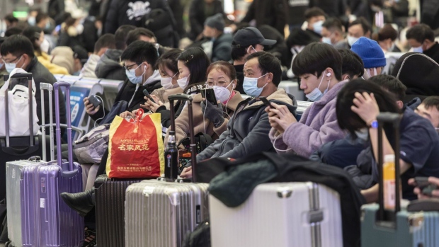 Travelers wearing protective masks wait in the main hall of the Hongqiao Railway Station ahead of Lunar New Year in Shanghai, China, on Sunday, Jan. 23, 2022. The Covid-19 outbreaks in multiple Chinese cities are pressuring travel demand ahead of the Lunar New Year holiday. Photographer: Qilai Shen/Bloomberg