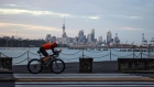A cyclist rides past the city's skyline in Auckland, New Zealand, on Tuesday, Nov. 23, 2021. New Zealand's central bank is expected to raise interest rates for a second straight month and signal a more aggressive tightening cycle to contain inflation amid a labor shortage.