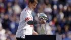 EAST RUTHERFORD, NEW JERSEY - OCTOBER 17: Former New York Giants quarterback Eli Manning walks onto the field carrying the Vince Lombardi Trophy during a ceremony honoring the 2011 Giants Super Bowl team at halftime during a game against the Los Angeles Rams at MetLife Stadium on October 17, 2021 in East Rutherford, New Jersey. (Photo by Sarah Stier/Getty Images)