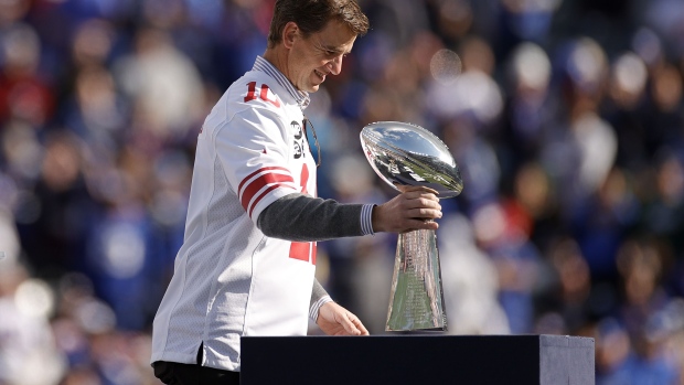 EAST RUTHERFORD, NEW JERSEY - OCTOBER 17: Former New York Giants quarterback Eli Manning walks onto the field carrying the Vince Lombardi Trophy during a ceremony honoring the 2011 Giants Super Bowl team at halftime during a game against the Los Angeles Rams at MetLife Stadium on October 17, 2021 in East Rutherford, New Jersey. (Photo by Sarah Stier/Getty Images)