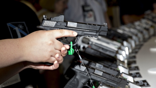 An attendee holds a Smith & Wesson Corp. pistol at the company's booth during the National Rifle Association (NRA) annual meeting in Dallas, Texas, U.S., on Saturday, May 5, 2018. President Donald Trump delivered a strong sign of support for the National Rifle Association at its annual meeting on Friday, as gun-rights advocates regroup in the wake of the mass shooting at a Florida high school. Photographer: Daniel Acker/Bloomberg