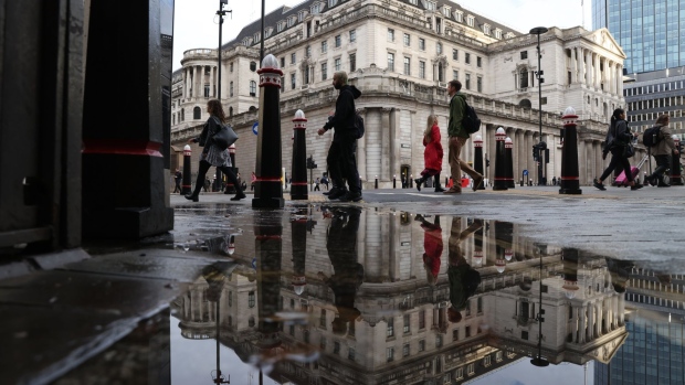 Pedestrians pass the Bank of England in the City of London, U.K., on Wednesday, Oct. 20, 2021. The U.K. Treasury is resisting pressure to increase spending in next week's budget because of concern that doing so would backfire by prompting the BOE to raise interest rates more aggressively. Photographer: Hollie Adams/Bloomberg