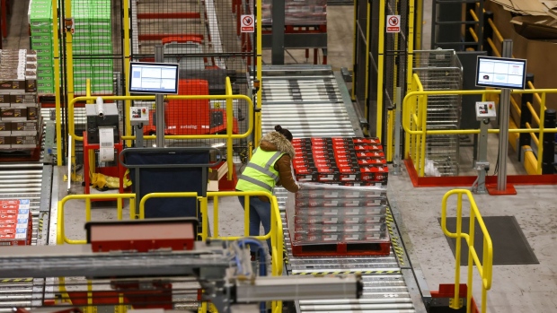An employee wraps a pallet of KitKat chocolate bars, manufactured by Nestle SA, at a distribution warehouse operated by GXO Logistics Inc. near Derby, U.K., on Friday, Dec. 10, 2021. British logistics companies are taking steps to boost training, recruitment and pay, "yet there remains concern that some supply chain disruption will continue in 2022 until these crucial roles are filled across the industry," a report by trade organization Logistics UK warned.