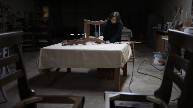 A factory worker sandpapers a handmade chair at a wood shop in Auburn, Kentucky. Photographer: Luke Sharrett/Bloomberg