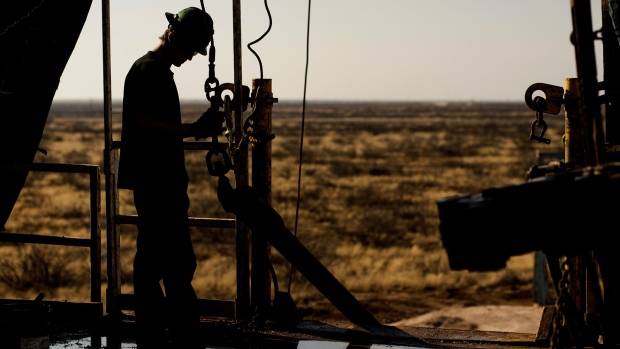 A worker waits to connect a drill bit on a rig in the Permian basin outside of Midland, Texas. Photographer: Brittany Sowacke/Bloomberg