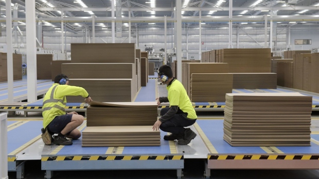 Employees check a stack of cardboard at the end of a conveyor at a Visy Industries Australia Pty factory in Melbourne, Australia, on Tuesday, April 27, 2021. As Covid-19 forced people to stay home, more online shopping led to increased demand for packaging. Sales jumped 30% to more than $4 billion, according to the Visy.