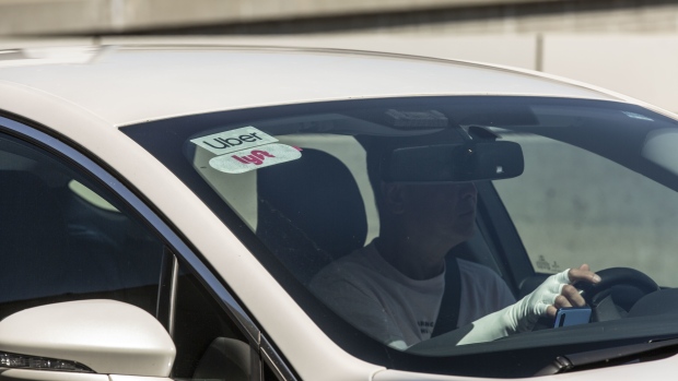 Distintivos de Lyft Inc. y Uber Technologies Inc. en el parabrisas de un vehículo en el aeropuerto internacional de los Ángeles. Photographer: Allison Zaucha/Bloomberg