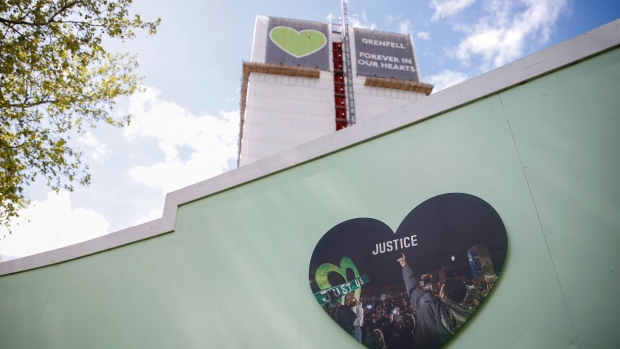 A heart-shaped board reading 'Justice' outside the remains of Grenfell Tower in North Kensington, London, U.K., on Wednesday, May 12, 2021. An extreme example of gentrification is the district of Notting Hill, synonymous with slums and race riots in the postwar period before turning into one of the most highly coveted parts of the British capital.