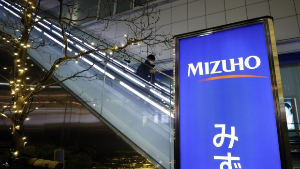 Illuminated signage for Mizuho Bank Ltd., a unit of Mizuho Financial Group Inc. (MHFG), displayed outside a branch in Tokyo, Japan, on Monday, Jan. 31, 2022. Mizuho Financial Group is scheduled to release its third-quarter earnings announcement on February 2. Photographer: Kiyoshi Ota/Bloomberg