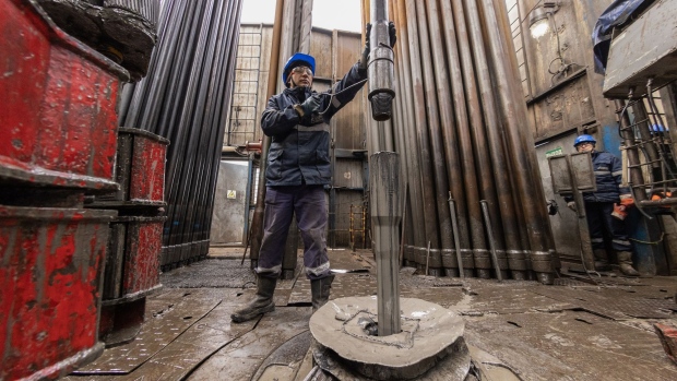 A worker guides drilling pipes at a gas drilling rig on the Gazprom PJSC Chayandinskoye oil, gas and condensate field, a resource base for the Power of Siberia gas pipeline, in the Lensk district of the Sakha Republic, Russia, on Wednesday, Oct. 13, 2021. European natural gas futures declined after Russia signaled that it may offer additional volumes soon. Photographer: Andrey Rudakov/Bloomberg