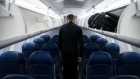A flight attendant walks on board a Delta Air Lines plane. Photographer: Al Drago/Bloomberg