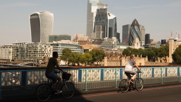 Cyclists cross Tower Bridge in front of skyscrapers on the City of London Financial district skyline in London, U.K. on Monday, Aug. 10, 2020. With a budget of £2 billion ($2.57 billion) over the next five years, Britain will launch Active Travel England to fund to improve cycle and pedestrian infrastructure across the country. Photographer: Jason Alden/Bloomberg