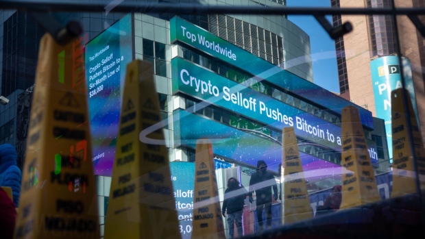 Monitors display financial news about a cryptocurrency selloff outside the Morgan Stanley headquarters in New York, U.S., on Friday, Jan. 21, 2022. With the worst start of a year in more than a decade and a $2.2 trillion wipeout in market value, the Nasdaq Composite Index couldn't have had a messier kickoff to 2022.
