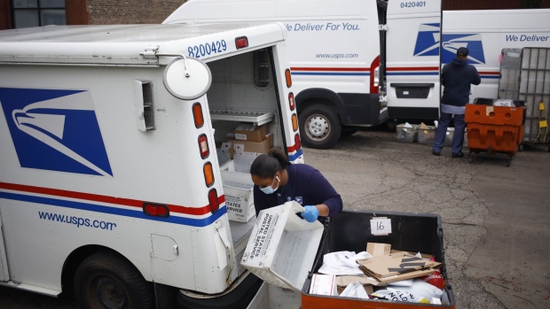 Workers load mail into delivery vehicles outside a United States Postal Service (USPS) distribution center in Chicago, Illinois, U.S., on Tuesday, Oct. 12, 2021. FedEx, UPS, Amazon.com and the U.S. Postal Service are busy hiring temporary and part-time workers ahead of the peak season, which will start to ramp up in November. Competition will be fierce for labor in and out of the parcel industry.