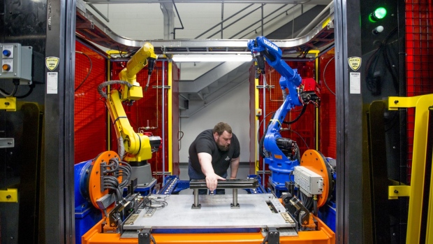 A worker adjusts a robotic MIG welding cell during the opening of the Martinrea International Inc. technical center in Auburn Hills, Michigan, U.S., on Thursday, May 17, 2018. Martinrea, Canada's third largest manufacturer of auto parts, cut the ribbon Thursday on a new technical center that will employ about 200 people once it's at full capacity.