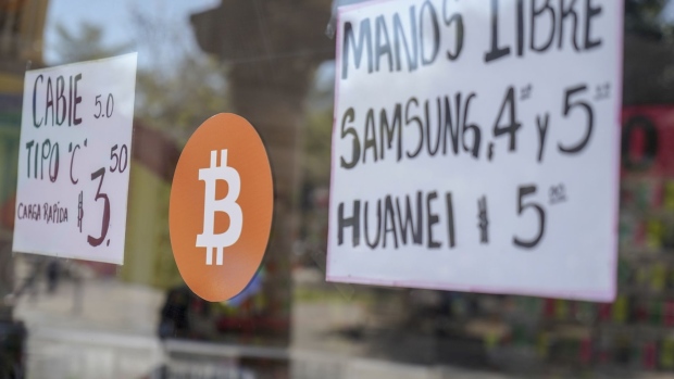 A sign announcing the acceptance of Bitcoin as a payment method displayed at a store in San Salvador, El Salvador, on Saturday, Jan. 29, 2022. The International Monetary Funds board urged El Salvador to strip Bitcoin of its status as legal currency due to its large risks, highlighting a major obstacle for the nations efforts to get a loan from the institution.