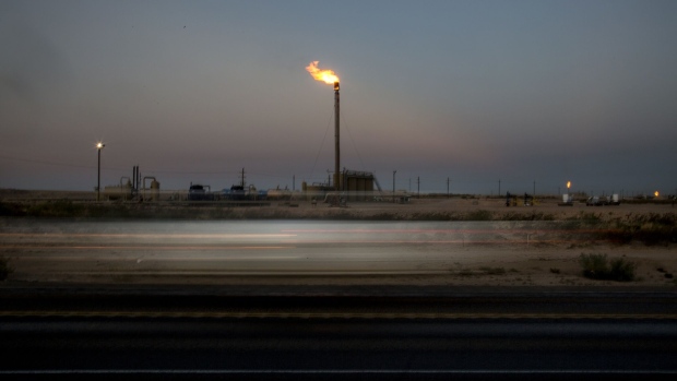 Gas flares stand in a field as light trails from a passing vehicle are seen on Highway 285 near Orla, Texas, U.S., on Saturday, Aug. 31, 2019. Natural gas futures headed for the longest streak of declines in more than seven years as U.S. shale production outruns demand and inflates stockpiles. Photographer: Bronte Wittpenn/Bloomberg