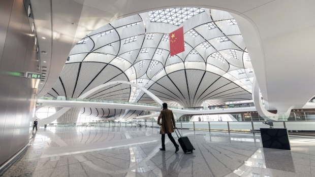 A traveler walks through the Beijing Daxing International Airport in Beijing, China, on Tuesday, Nov. 23, 2021. China’s marked economic slowdown in the second half of the year is testing the central bank’s policy mettle and dividing economists over whether more aggressive action is needed to avoid a deeper downturn.
