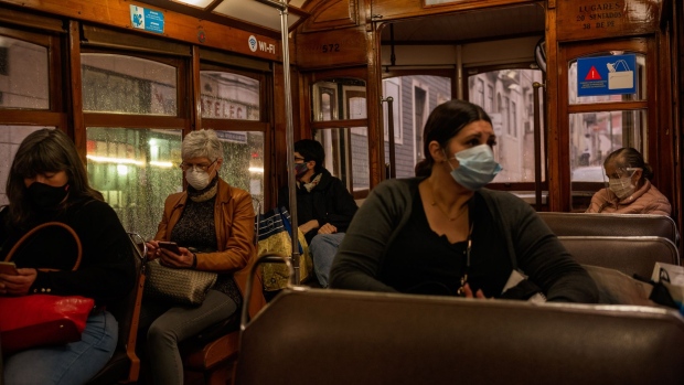 Commuters wearing protective face masks ride a tram in Lisbon, Portugal on Thursday, May 14, 2020. The European Union’s executive arm pushed for a continent-wide revival of tourism with a series of policy recommendations for EU countries as they loosen lockdowns triggered by the coronavirus pandemic.