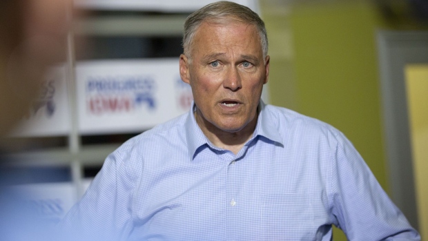 Jay Inslee, governor of Washington and 2020 presidential candidate, speaks to members of the media after arriving late and missing his speaking slot during the Progress Iowa Corn Feed in Cedar Rapids, Iowa, U.S., on Sunday, July 14, 2019. Democratic candidates will report their second-quarter fundraising totals to the Federal Election Commission on Monday, offering fresh insight into which candidates are managing the delicate balancing act of stockpiling enough cash to last through next year's primaries and spending that money to build up their campaign machines.