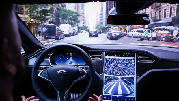 A driver rides hands-free in a Tesla Motors Inc. Model S vehicle equipped with Autopilot hardware and software in New York, U.S. on Monday, Sept. 19, 2016. The latest overhaul of the car's operating system, known as Tesla 8.0, biggest change is how Autopilot shifts towards a heavier reliance on its radar than its camera to guide the car through traffic.