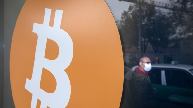 The logo of Bitcoin cryptocurrency at a store in Hong Kong, China, on Thursday, Feb. 10, 2022. Employees all over the world are opting to get paid in cryptocurrencies, though they're still in a small minority, according to global payrolls and hiring company Deel. Photographer: Paul Yeung/Bloomberg