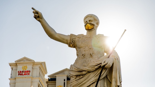 A statue of Julius Caesar wears a mask at the entrance of the Caesars Entertainment Inc. Caesars Palace hotel and casino in Las Vegas, Nevada, U.S., on Tuesday, July 28, 2020. Caesars Entertainment is scheduled to release earnings figures on August 6. Photographer: Roger Kisby/Bloomberg