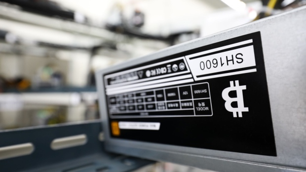 The bitcoin logo is displayed on a power supply unit at a cryptocurrency mining facility in Incheon, South Korea, on Friday, Dec. 15, 2017. Hedge funds are pulling out of gold bets as more exciting moves in equities and cryptocurrencies make safe-haven investments look boring.
