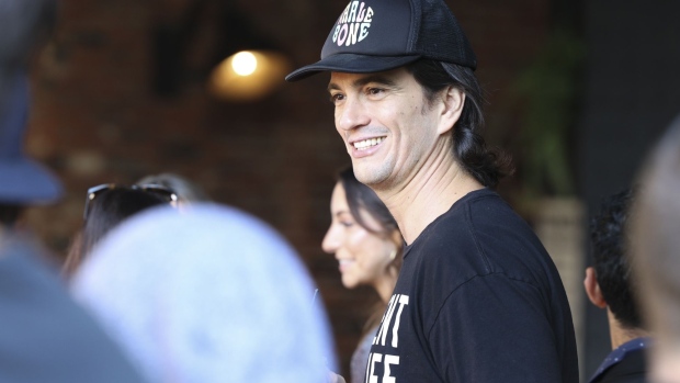 Adam Neumann, co-founder of WeWork, center, during an event on the sidelines of the company's trading debut in New York, U.S., on Thursday, Oct. 21, 2021. As WeWork completes its second attempt to go public, this time through a SPAC valuing the combined company at $9 billion, Neumann's name is peppered 197 times throughout the business combination filing, even though he's no longer an employee or board member.