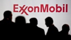 Attendees stand near Exxon Mobil Corp. signage. Photographer: Andrew Harrer/Bloomberg