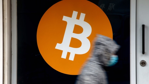 The logo of Bitcoin cryptocurrency at a store in Hong Kong, China, on Thursday, Feb. 10, 2022. Employees all over the world are opting to get paid in cryptocurrencies, though they're still in a small minority, according to global payrolls and hiring company Deel.