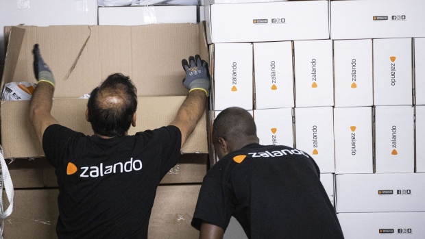 Employees load a delivery truck with branded boxes inside the Zalando SE online shopping logistics and fulfillment center in Erfurt, Germany, on Thursday, Aug. 15, 2019. Buying clothing online is popular in Europe's largest economy, but it's also the category that gets returned the most because many shoppers buy more than they need to try on different garments in the comfort of their own home. Photographer: Alex Kraus/Bloomberg