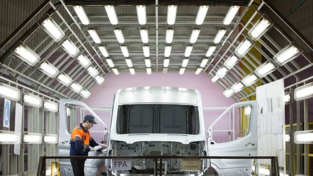 A worker checks the body shell of a Ford Transit van in a light tunnel on the production line at the Ford Sollers production plant in Elabuga, Russia.