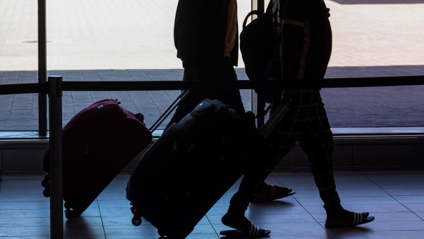 Passengers wheel their luggage inside the departures terminal at Cape Town International Airport.