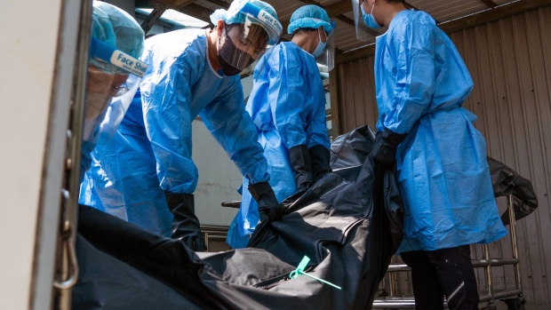 Workers at a mortuary move the body of a deceased person in Hong Kong, on March 4.