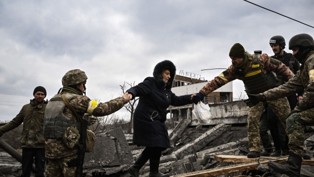   Une femme est assistée par des militaires ukrainiens tandis que des personnes traversent un pont détruit alors qu'elles évacuent la ville d'Irpin, au nord-ouest de Kiev, lors de bombardements et de bombardements intensifs le 5 mars 2022, 10 jours après que la Russie a lancé une armée en vasion sur l'Ukraine Photographe : Aris Messinis/AFP/Getty Images