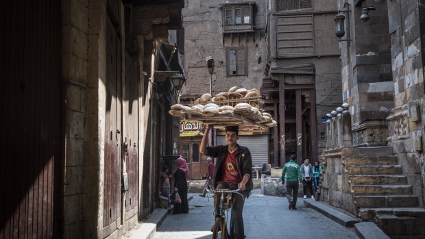 A cyclist balances a bread board on his head as he rides in Cairo, Egypt on March 31, 2018. Egyptian President Abdel-Fattah El-Sisi was set to sweep to victory with more than 90 percent of the vote in this week's election, crushing his one token challenger after credible competitors were eliminated before the contest.