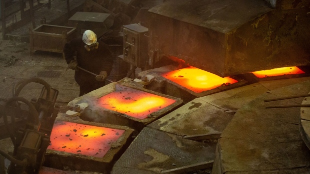 A worker inspects a newly-cast copper anode sheet as it cools in its mold in the metallurgical plant, in Monchegorsk, Russia.
