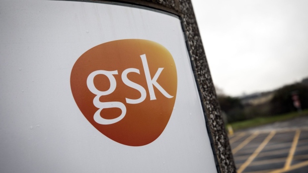 The GSK company logo is displayed on a sign outside the GlaxoSmithkline Plc Research and Development center in Stevenage, U.K., on Tuesday, Nov. 26, 2019. Glaxo is exploring the trillions of microbes that inhabit the gut in pursuit of novel ways to prevent some of the world’s most common ailments. Photographer: Simon Dawson/Bloomberg