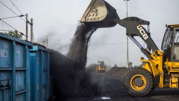 A JC Bamford Excavators Ltd. (JCB) front loader loads coal onto a freight wagon at the Tori Siding on the Tori-Shivpur rail line, operated by Indian Railways and funded by Coal India Ltd., in Chandwa, Jharkhand, India, on Thursday, May 17, 2018. State miner Coal India's output and shipments jumped to seasonal records in June, buoyed by summer demand from power stations, the company's biggest customers.