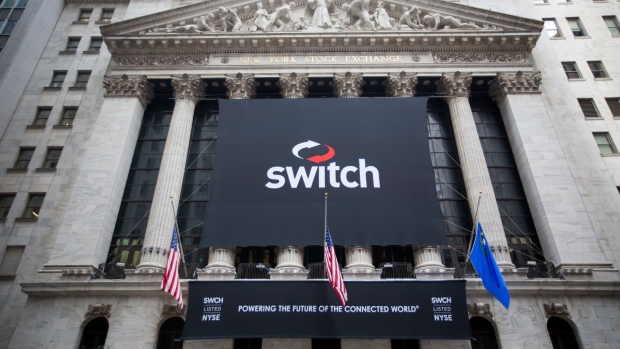 Rob Roy, founder and chief executive officer of Switch Inc., center, tours the floor of the New York Stock Exchange (NYSE) during the company's initial public offering (IPO) in New York, U.S., on Friday, Oct. 6, 2017. Switch jumped by almost half in its trading debut after raising $531 million in an initial public offering, the third-biggest technology IPO this year in the U.S..