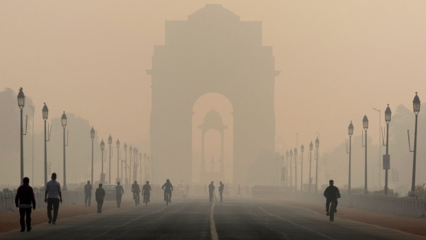 Bloomberg Best of the Year 2019: Pedestrians walk along Rajpath boulevard as India Gate monument stands shrouded in smog in New Delhi, India, on Tuesday, Nov. 5, 2019. Photographer: Ruhani Kaur/Bloomberg