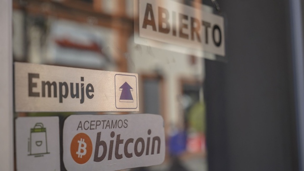 A sign announcing the acceptance of Bitcoin as a payment method displayed at a coffee shop in San Salvador, El Salvador, on Saturday, Jan. 29, 2022. The International Monetary Funds board urged El Salvador to strip Bitcoin of its status as legal currency due to its large risks, highlighting a major obstacle for the nations efforts to get a loan from the institution. Photographer: Camilo Freedman/Bloomberg