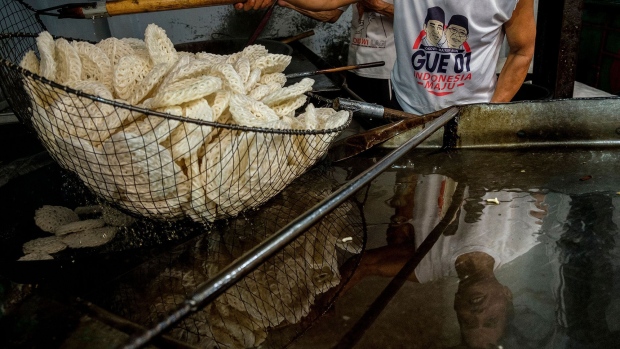 JAKARTA, INDONESIA - FEBRUARY 11: Indonesian men fry krupuk, a rice cracker served with most meals, at a small factory on February 11, 2022 in Jakarta, Indonesia. The price of palm oil, an ingredient in many food products, has been rising due to reduced production caused by labor shortages due to the Covid-19 virus and weather problems in Indonesia and Malaysia, the world's primary producers. The Indonesian government is trying to keep prices down by asking producers to prioritize domestic needs over exports. (Photo by Ed Wray/Getty Images)