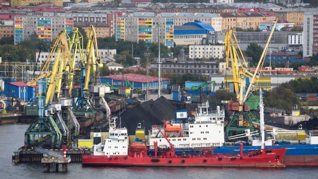 Cranes stand by a pile of coal at a terminal operated by Siberian Coal Energy Company (SUEK) at the Port of Murmansk, in Murmansk, Russia, on Saturday, Sept. 14, 2019. Crude and condensate shipments from Russia’s Arctic terminals are shipped in dedicated shuttle tankers to the Russian port of Murmansk where they are trans-shipped onto larger vessels for export. Photographer: Andrey Rudakov/Bloomberg