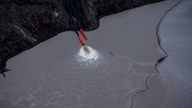 Water is pumped into a tailings pond at the Suncor Energy Inc. Steepbank mine in this aerial photograph taken above the Athabasca oil sands near Fort McMurray, Alberta, Canada, on Monday, Sept. 10, 2018. While the upfront spending on a mine tends to be costlier than developing more common oil-sands wells, their decades-long lifespans can make them lucrative in the future for companies willing to wait.