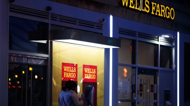 A pedestrian walks past automated teller machines (ATM) at a Wells Fargo bank branch at night in Washington, D.C., U.S., on Thursday, Jan. 7, 2021. Wells Fargo & Co. is scheduled to release earnings figures on January 15. Photographer: Ting Shen/Bloomberg